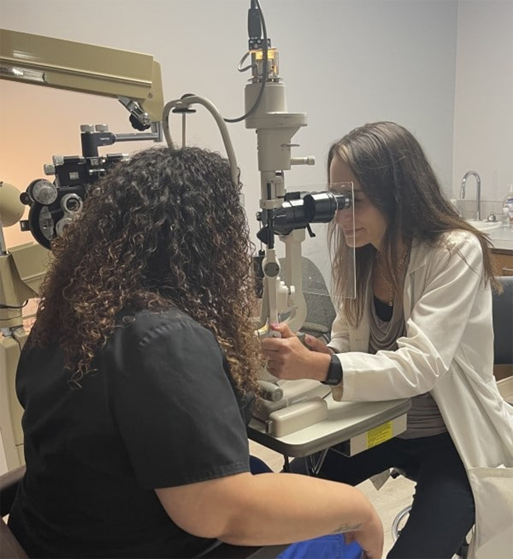 Dr. Alaina Kronenberg, M.D., an ophthalmologist, conducting an eye examination with a slit lamp on a patient in a clinical setting - Eye Doctor in Dearborn Dr. Alaina Kronenberg, M.D., an ophthalmologist, conducting an eye examination with a slit lamp on a patient in a clinical setting - Eye Doctor in Dearborn